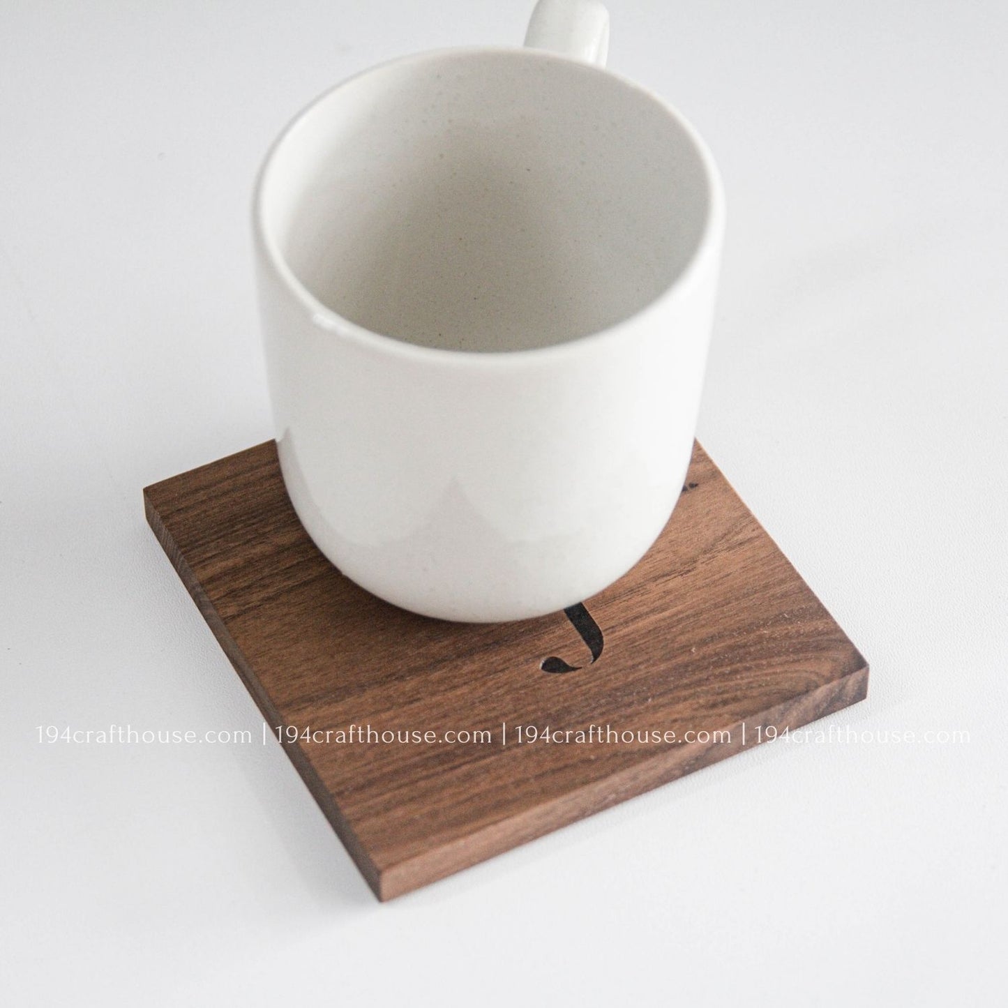 White mug on a wooden coaster with a white background