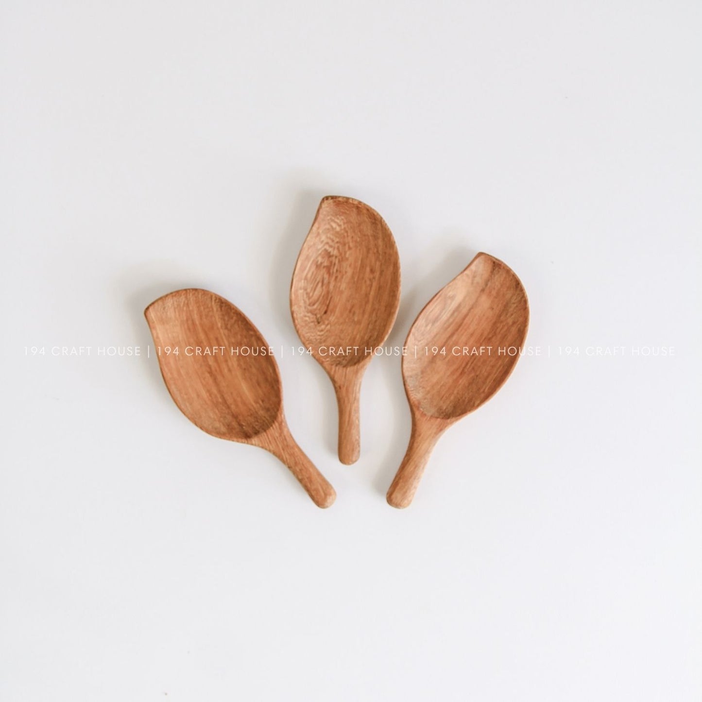 Handcrafted leaf-shaped wooden measuring scoops showcasing smooth finish and natural wood grain