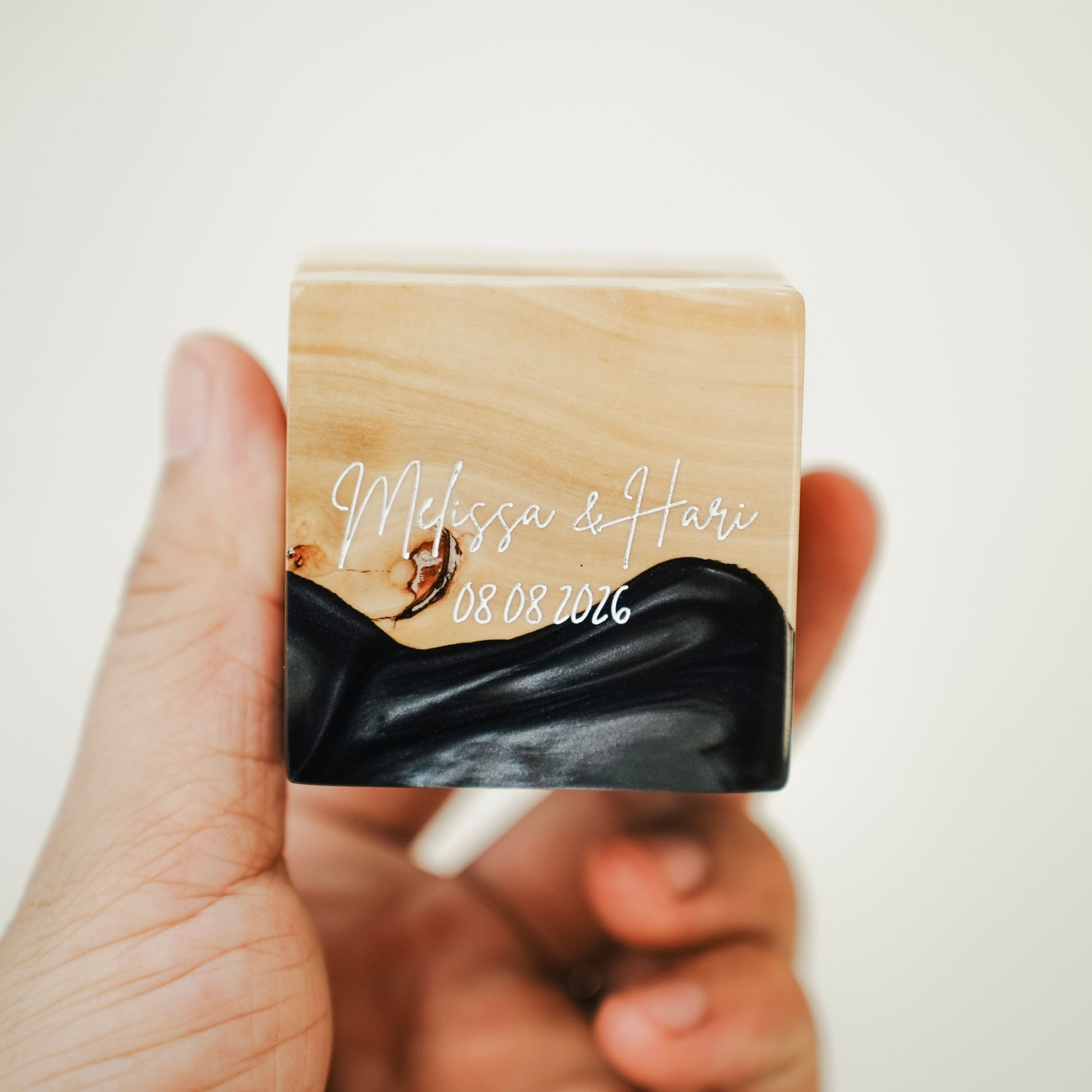 Custom engraved artisan ring box made of black epoxy resin and wood, showcasing a personalized name and date engraving