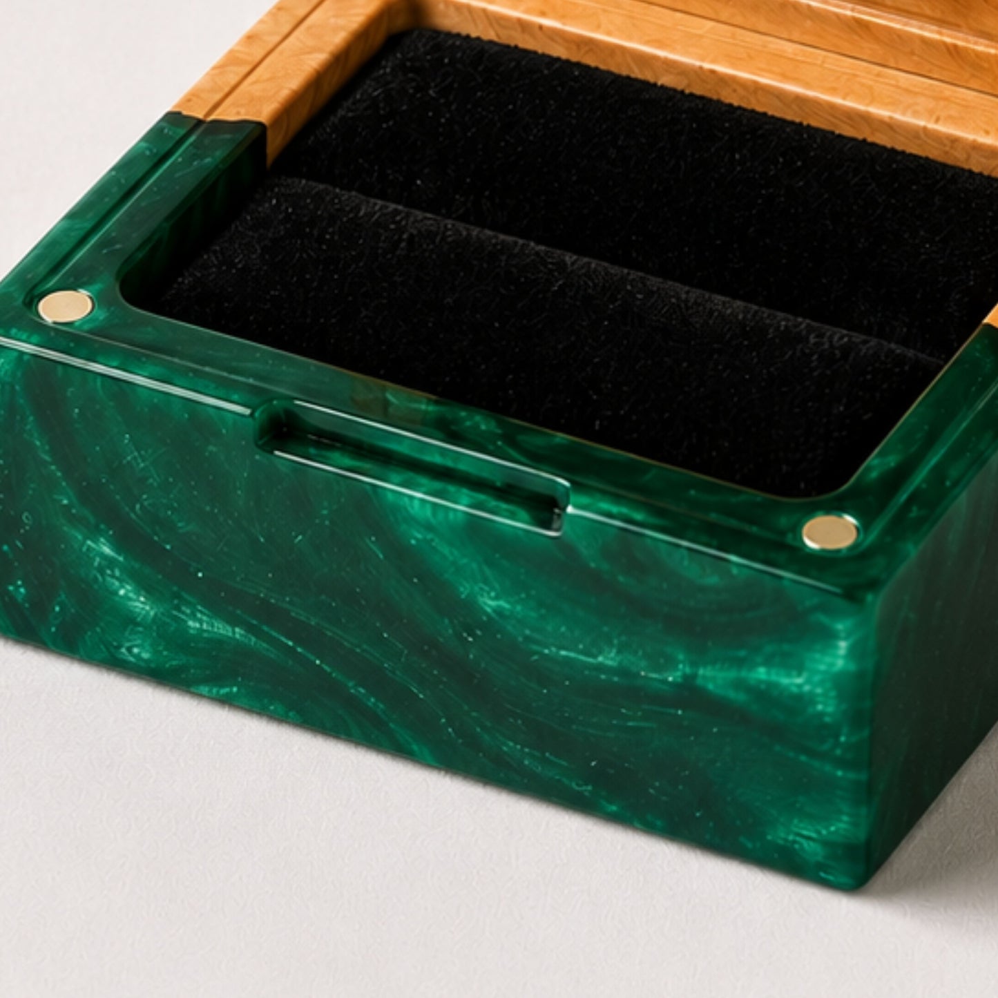 Close-up of an open square ring box made of green resin and burl wood with a black velvet interior and magnet closure.