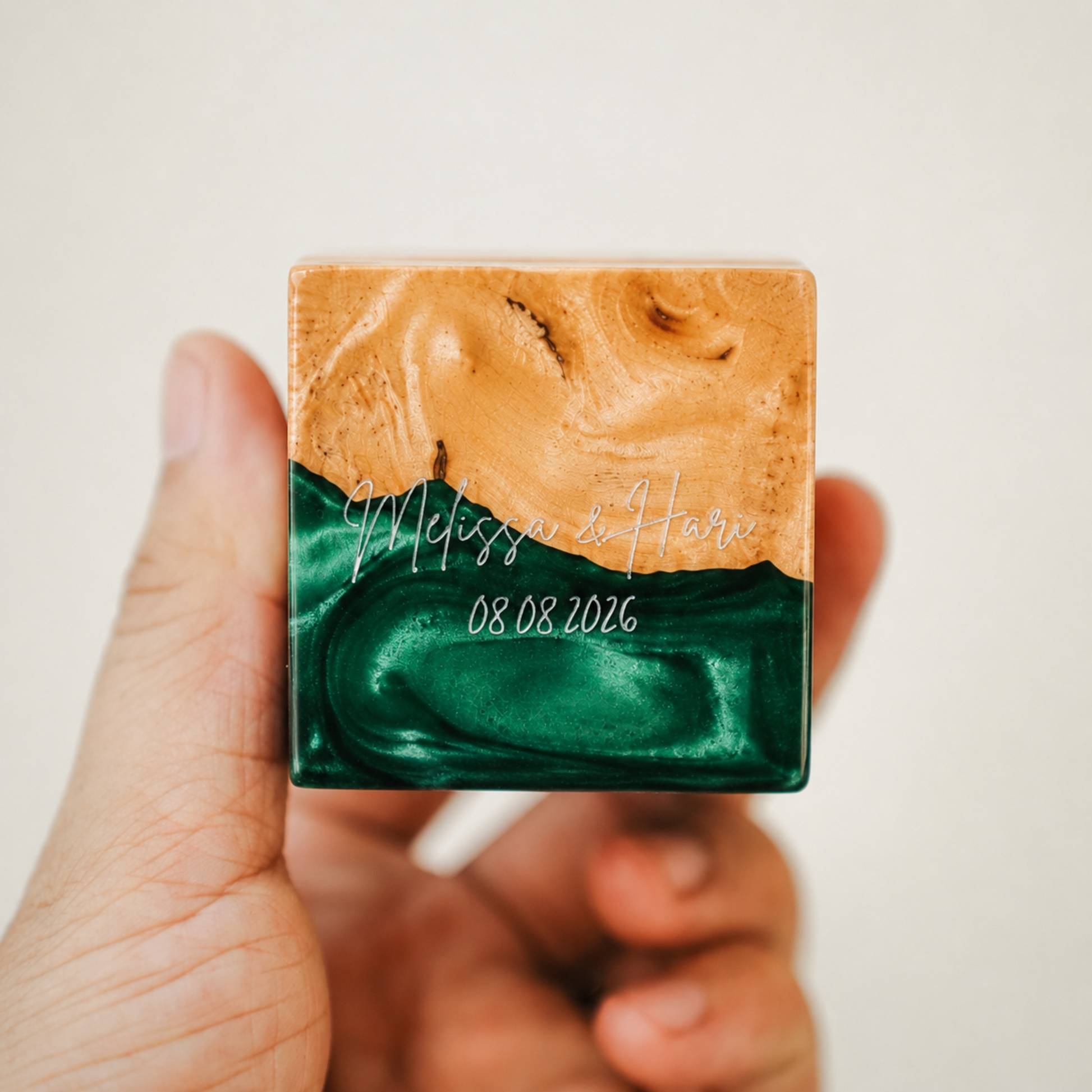 Custom engraved artisan ring box made of green epoxy resin and wood, showcasing a personalized name and date engraving