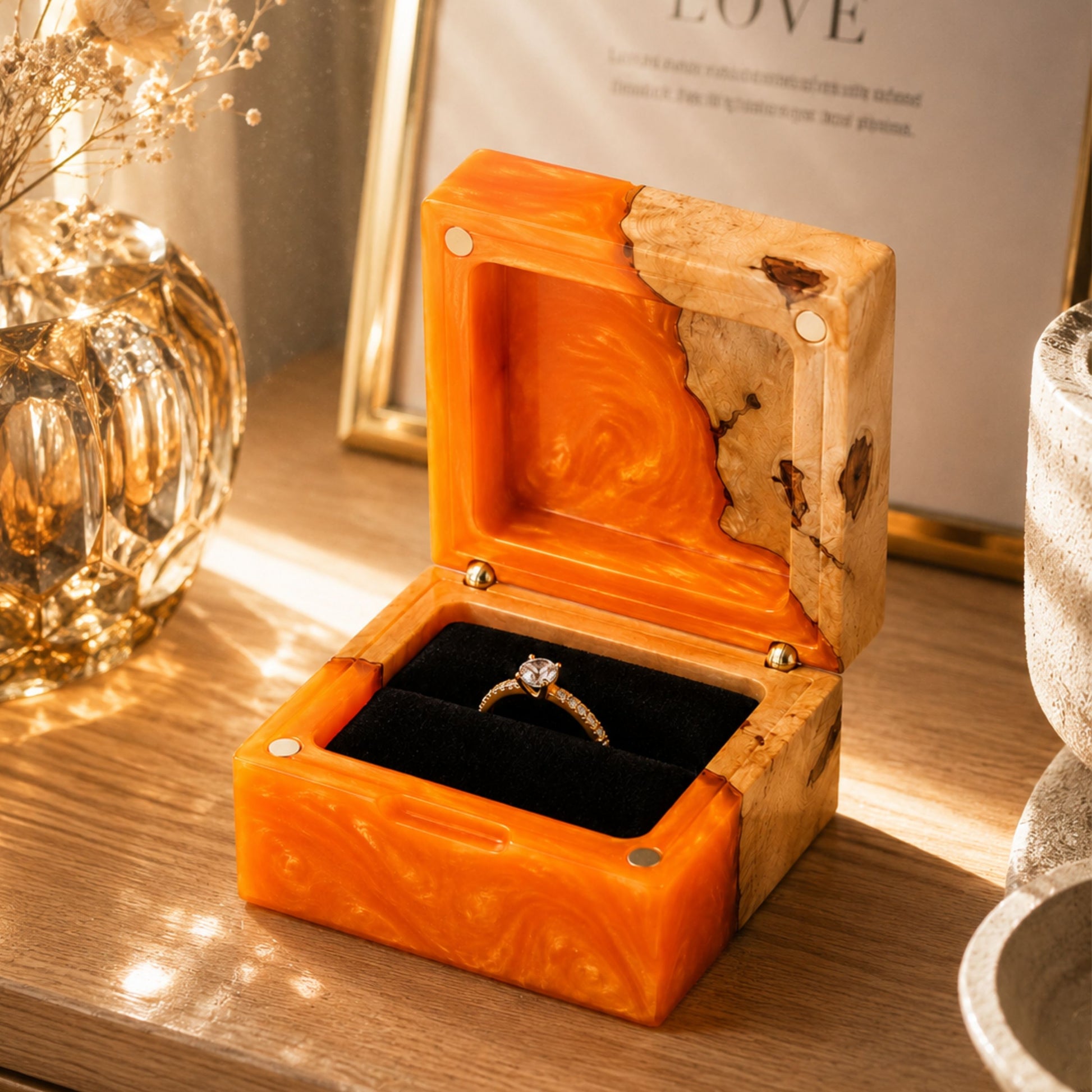 Open orange resin and natural burl wood engagement ring box holding a diamond ring on a rustic wooden table.