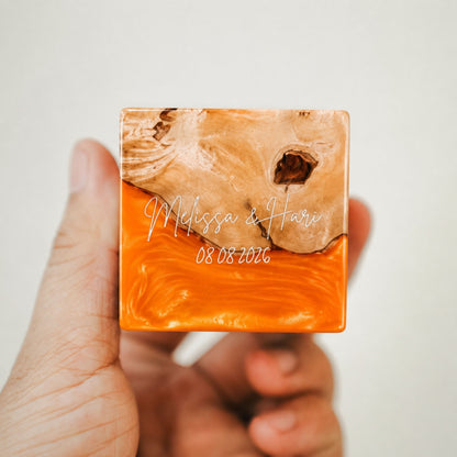 Custom engraved artisan ring box made of orange epoxy resin and wood, showcasing a personalized name and date engraving