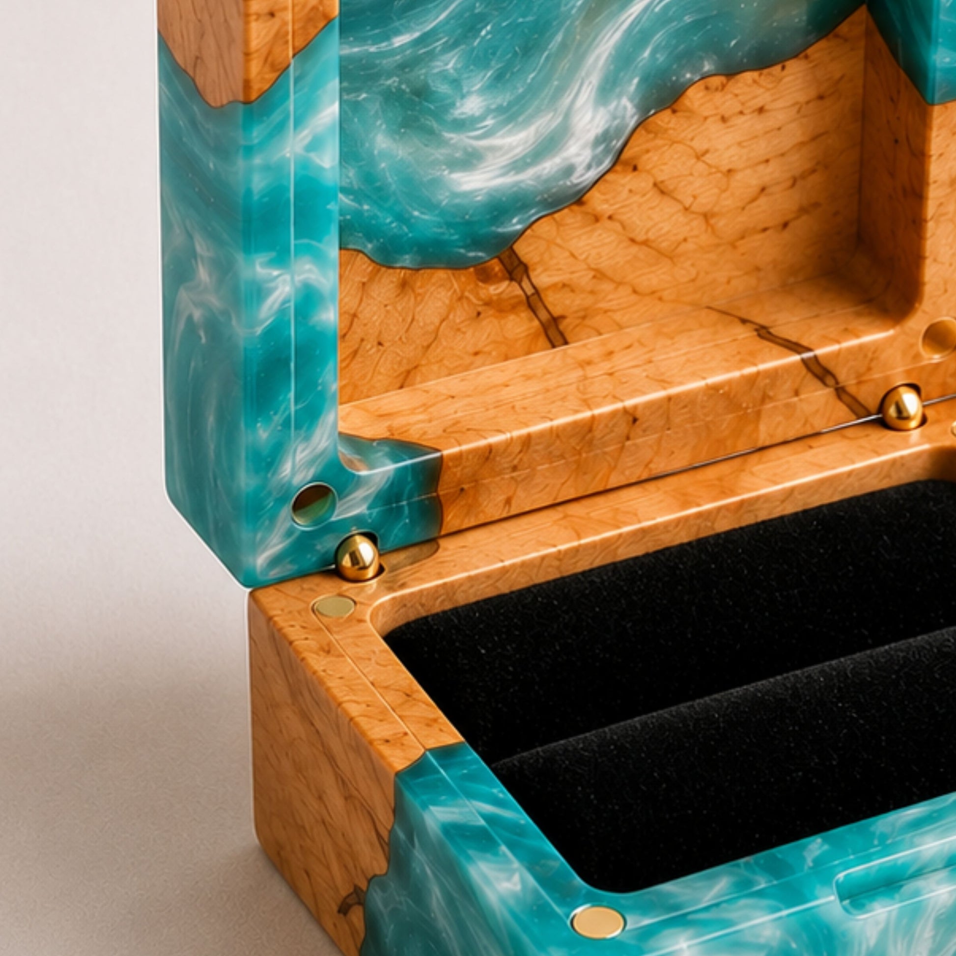 Close-up of an open square ring box made of turquoise resin and burl wood with a black velvet interior and magnet closure.