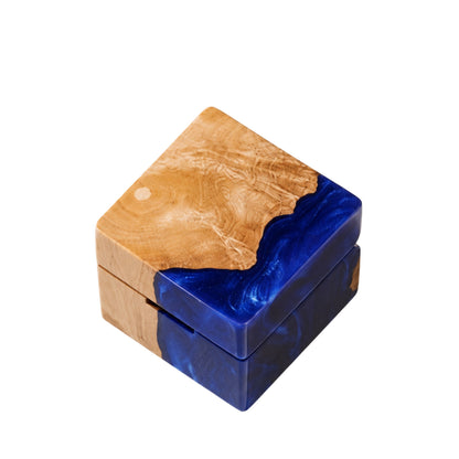 Square artisan wedding ring box made of blue epoxy resin and natural burl wood.