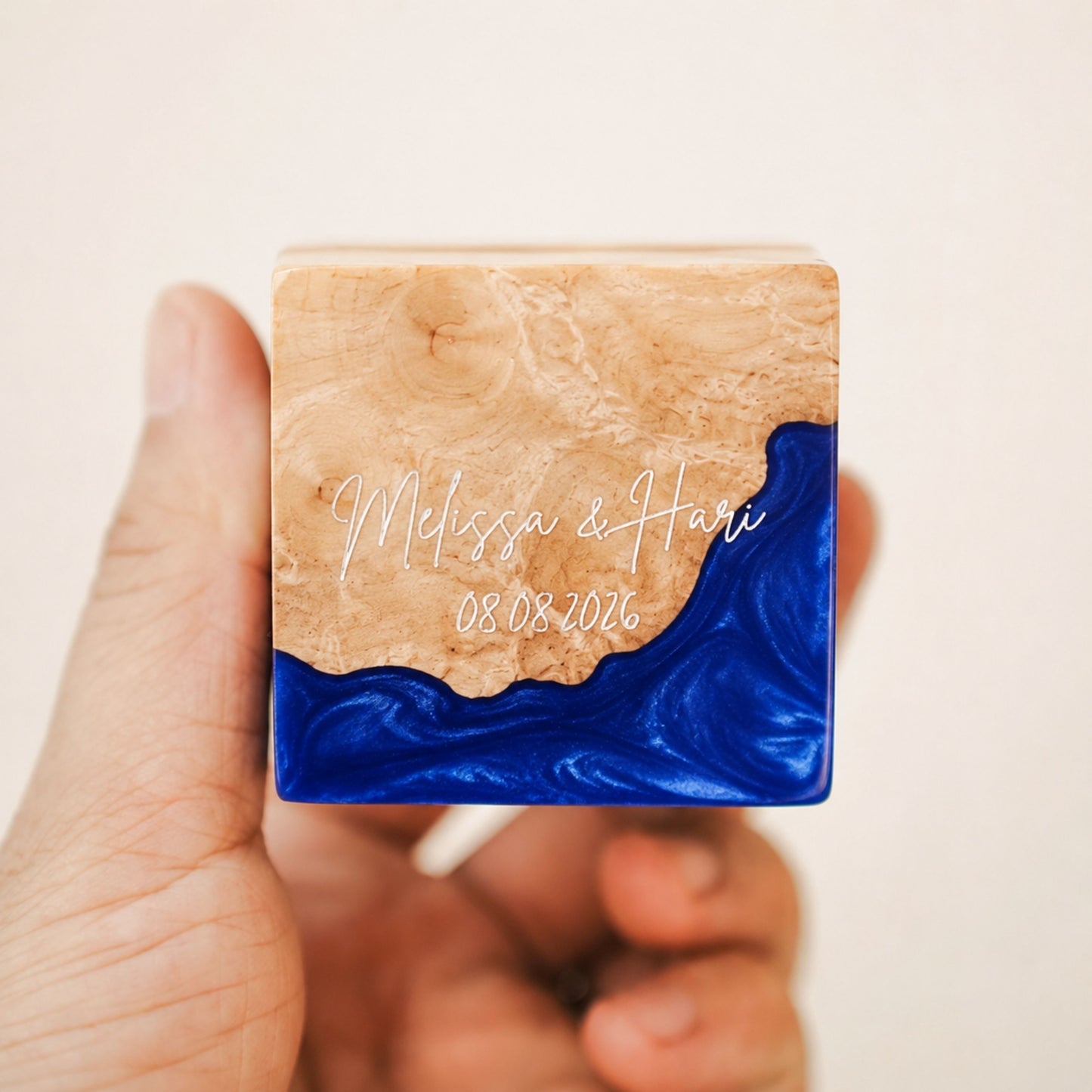 Custom engraved artisan ring box made of blue epoxy resin and wood, showcasing a personalized name and date engraving