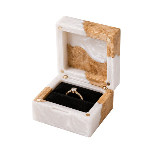 Open square engagement ring box made of pearl epoxy resin and natural burl wood, displaying a gold diamond ring on a black velvet lining