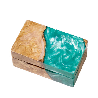 Top view of a closed rectangular ring box made from natural burl wood and swirled turquoise epoxy resin.
