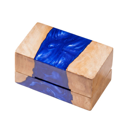 Top view of a closed rectangular ring box made from natural burl wood and swirled blue epoxy resin.
