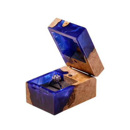 Open blue resin and natural wood ring box displaying the interior ring slots.