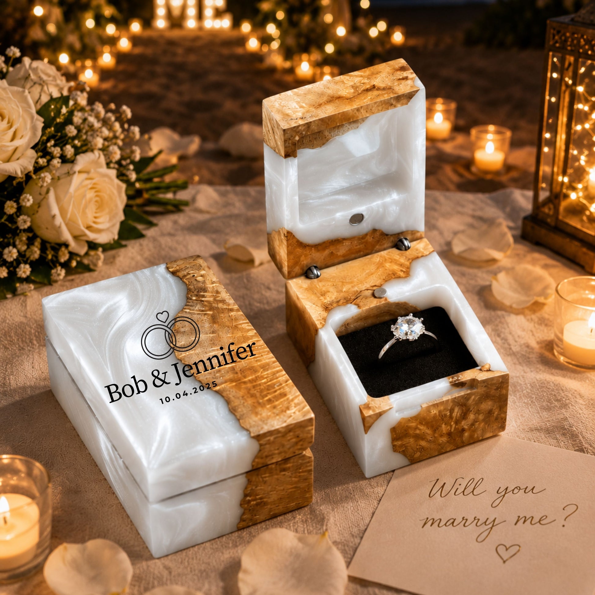 Personalized pearl white resin and wood ring box engraved with couple names and wedding date set in a romantic proposal scene with candles.