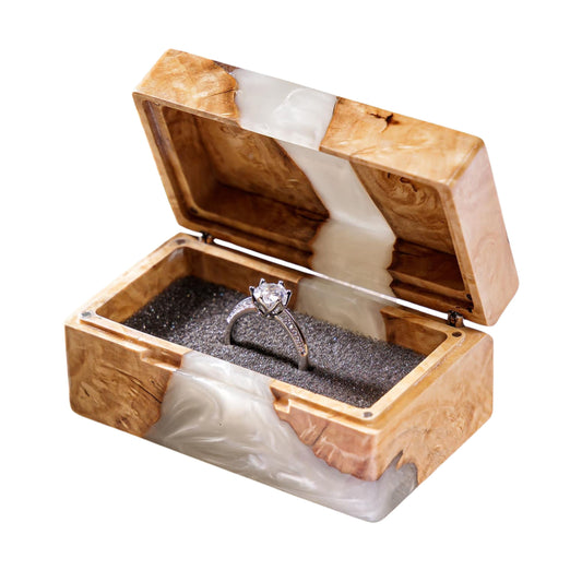 Open handcrafted wood and white pearl epoxy resin engagement ring box displaying a proposal diamond ring inside a black velvet slot.
