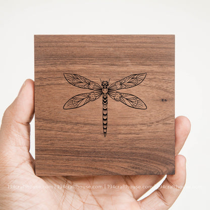 Dragonfly design engraved on a handcrafted square walnut wood coaster with natural grain