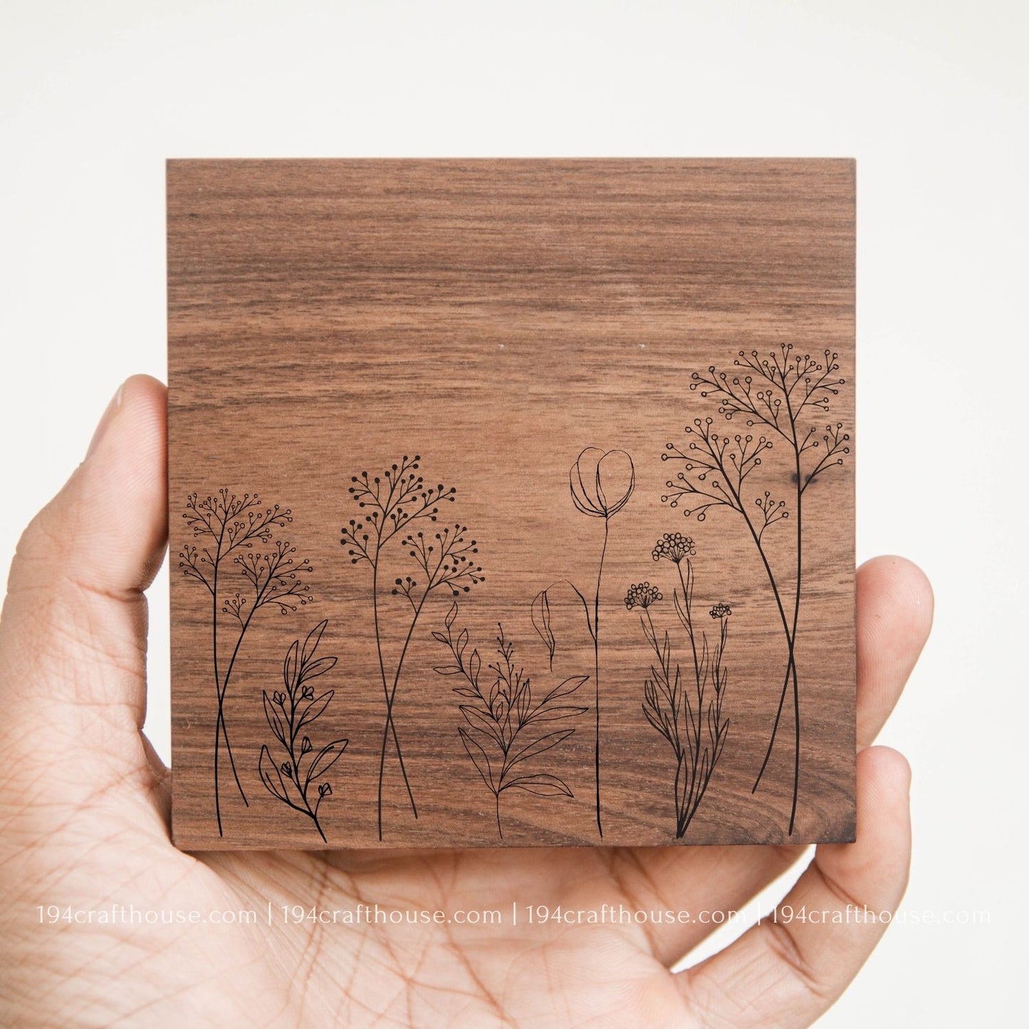 Floral design engraved on a handcrafted square walnut wood coaster with natural wood grain