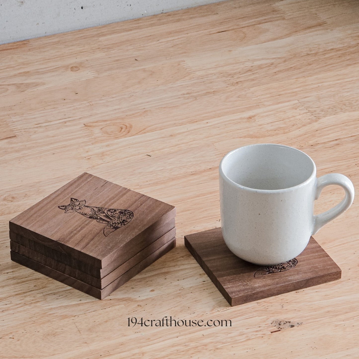 White coffee mug displayed on a square walnut wood coaster beside a matching wooden storage box