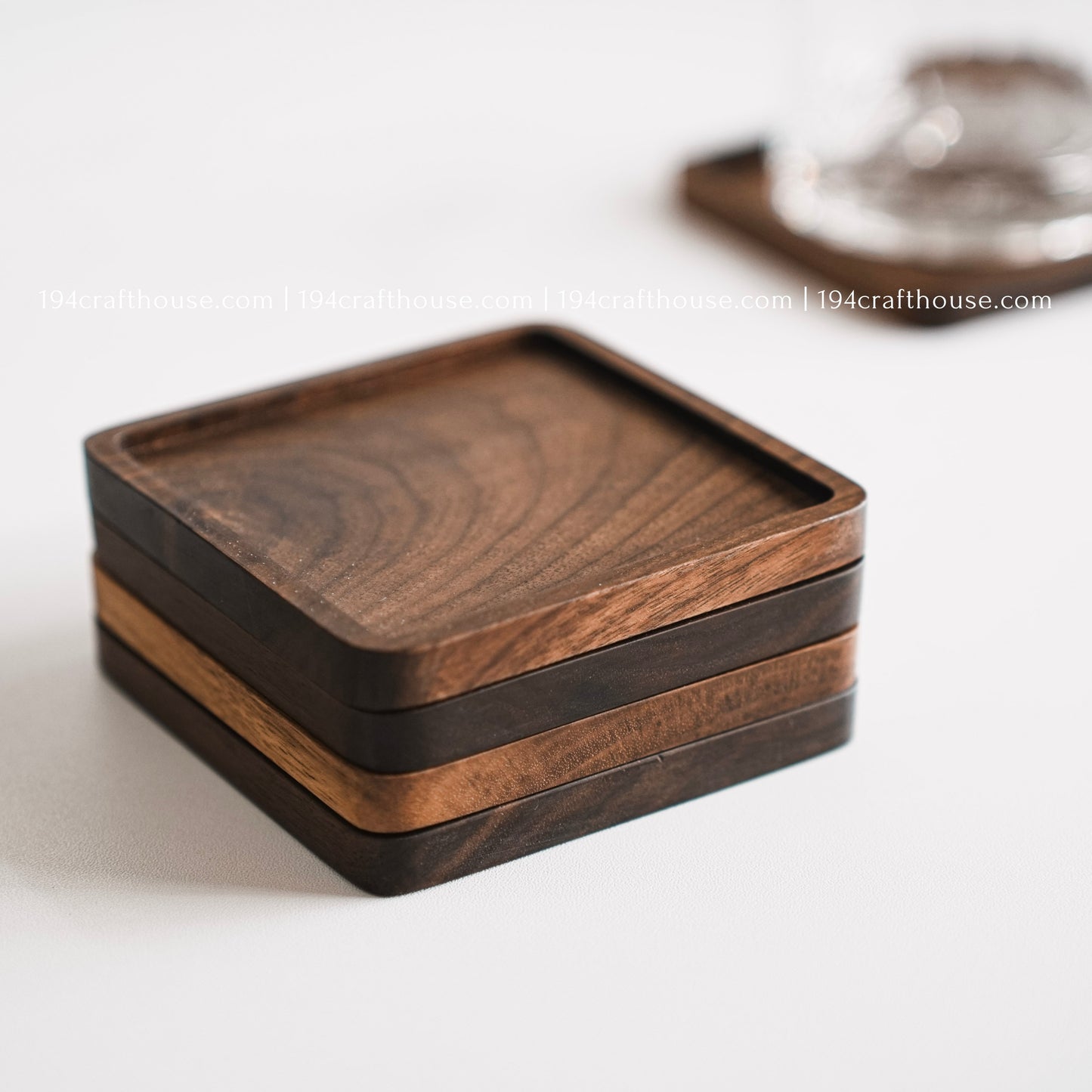 Top-down view of  a set of 4 square hand-carved walnut wood coasters with smooth rounded corners on a clean white surface by 194 Craft House