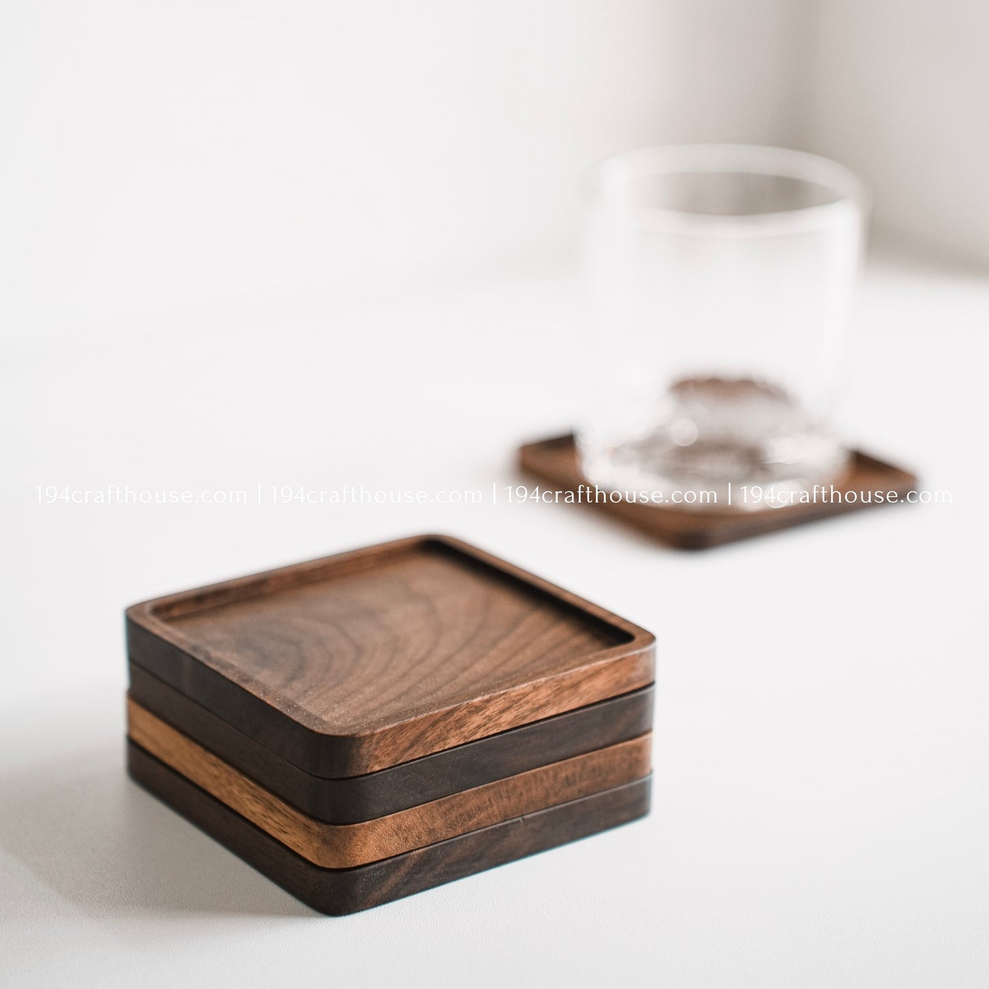 Top-down view of  a set of 4 square hand-carved walnut wood coaster with smooth rounded corners on a clean white surface by 194 Craft House