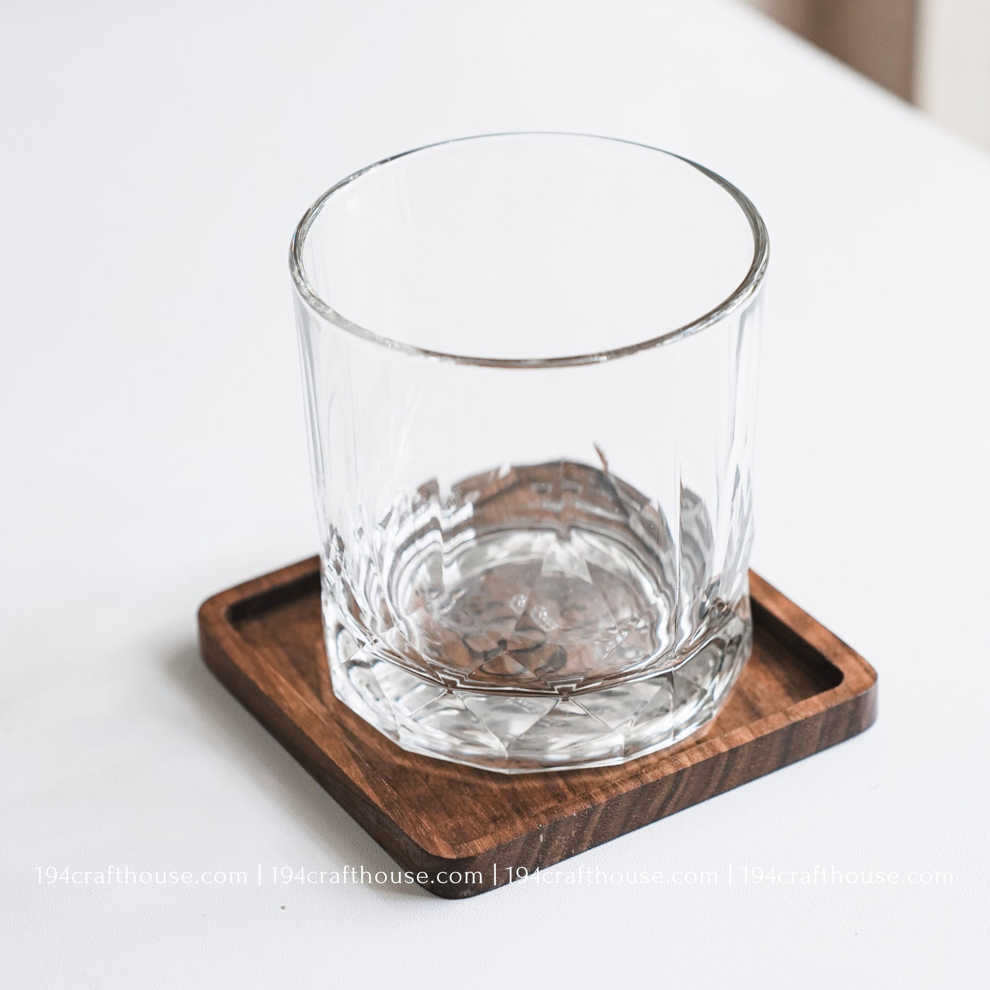Top-down view of a glass stand on a Best Mom Ever engraved on a single square hand-carved walnut wood coaster with smooth rounded corners on a clean white surface by 194 Craft House