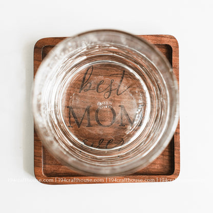 Top-down view of a glass stand on a Best Mom Ever engraved on a single square hand-carved walnut wood coaster with smooth rounded corners on a clean white surface by 194 Craft House
