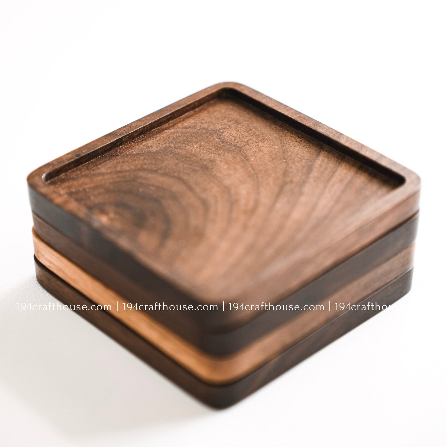 Top-down view of a set of 4 square hand-carved walnut wood coaster with smooth rounded corners on a clean white surface by 194 Craft House