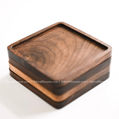 Top-down view of a set of 4 square hand-carved walnut wood coaster with smooth rounded corners on a clean white surface by 194 Craft House