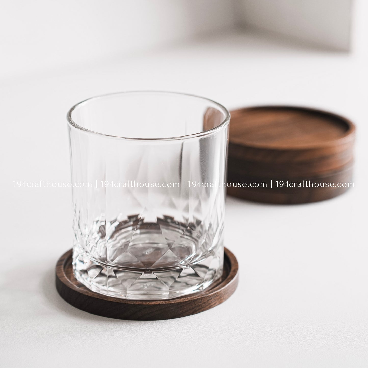 Top-down view of a single round hand-carved walnut wood coaster with smooth rounded corners on a clean white surface by 194 Craft House