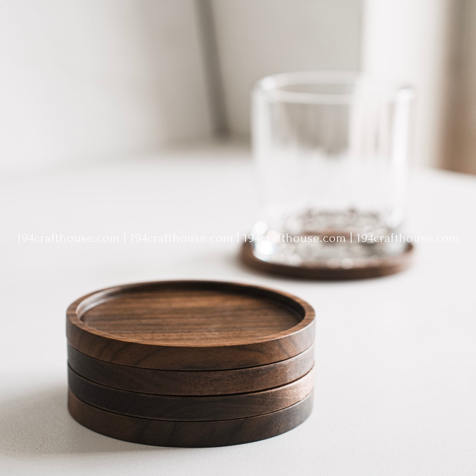 Top-down view of a set of 4 round hand-carved walnut wood coaster with smooth rounded corners on a clean white surface by 194 Craft House
