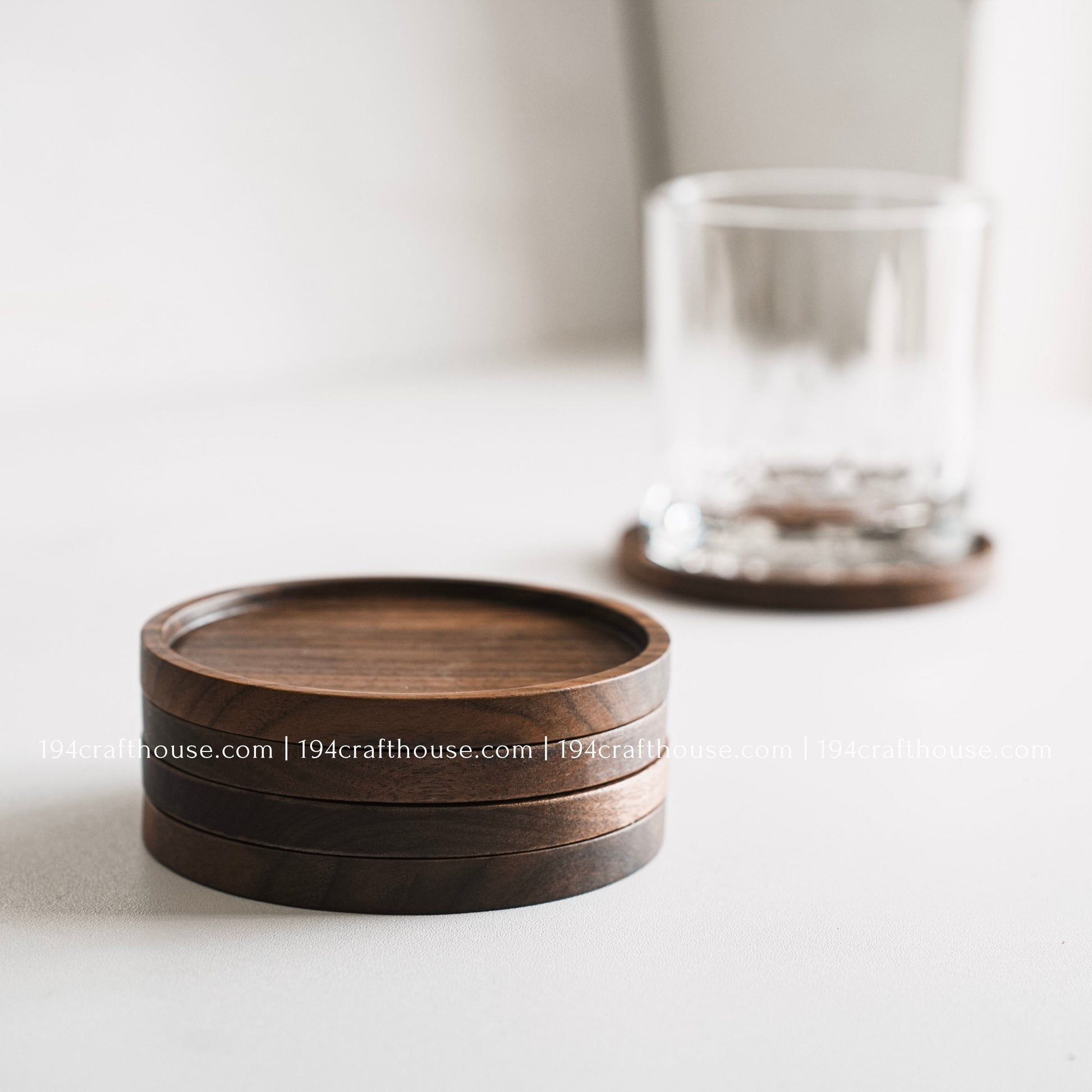 Top-down view of a set of 4 round hand-carved walnut wood coaster with smooth rounded corners on a clean white surface by 194 Craft House