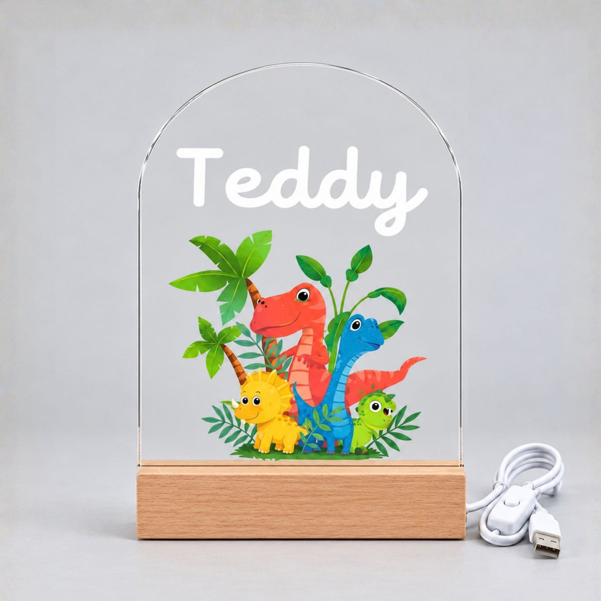 Night light switched off, showing Teddy's name, colorful dinosaurs, rounded panel, base, and cable