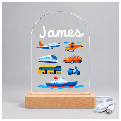 Front view of the unlit acrylic panel with the name James, colorful vehicles, and a white cable beside it.
