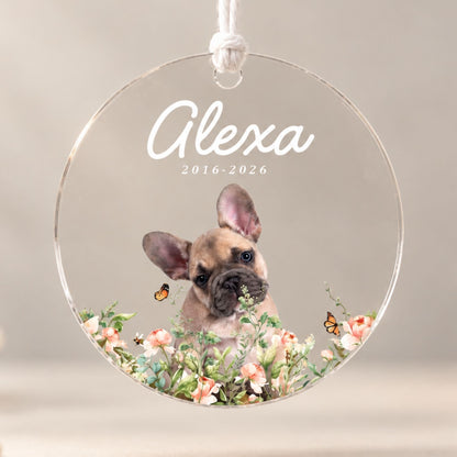 Studio front view of a round acrylic pet loss ornament printed with a French bulldog portrait, floral accents, and custom memorial dates on a neutral background.