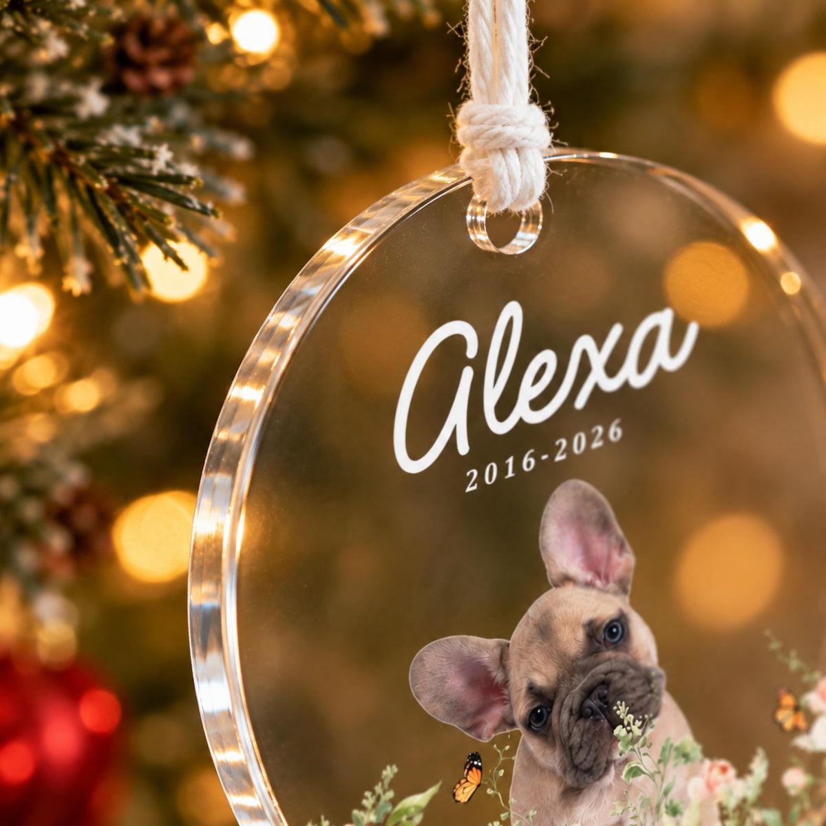 Macro detail shot of the top hanging hole and knotted white hanging cord loop on a clear acrylic pet memorial Christmas ornament.