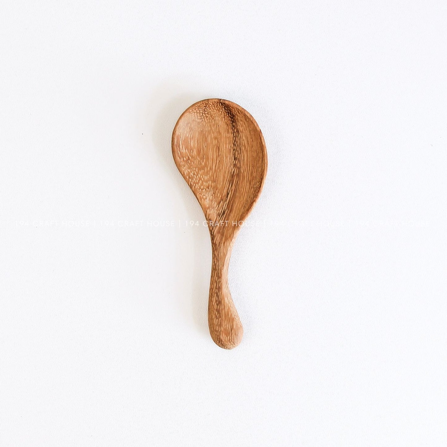 Hand-carved wooden spoon with a curved short handle, smooth finish, and natural wood grain
