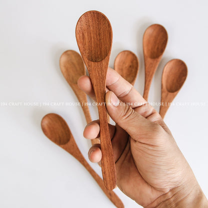 Handcrafted wooden coffee and tea measuring spoons held in hand to show size and natural wood grain