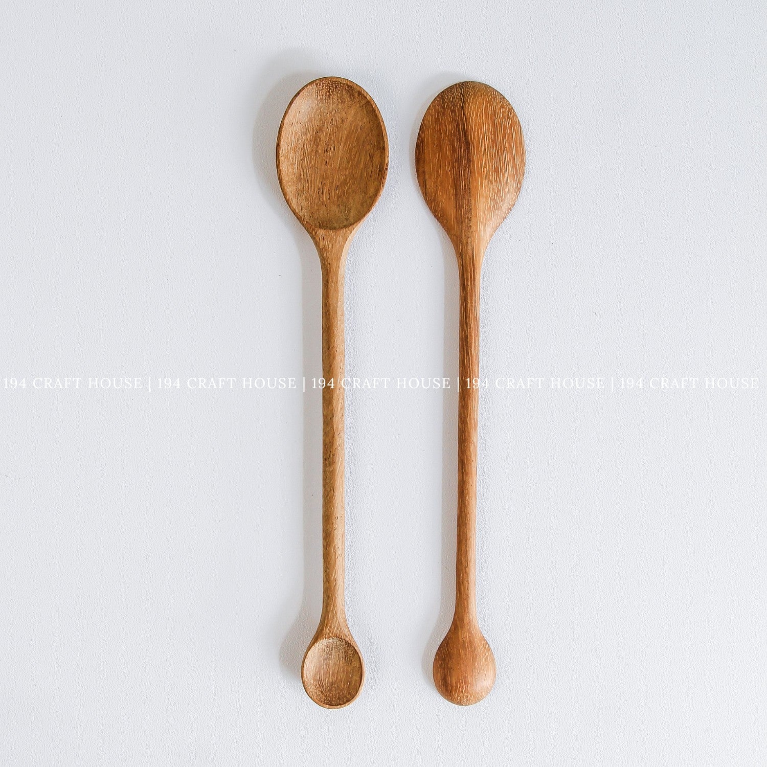 Pair of handcrafted double-ended wooden spoons with natural wood grain