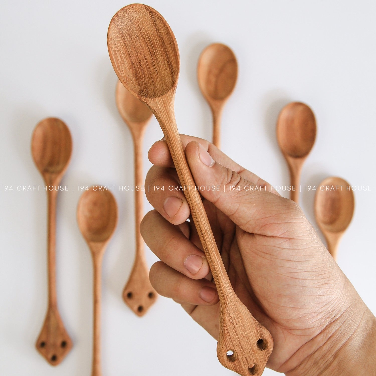 Handcrafted vintage wooden spoon held in hand to showcase its size and natural wood grain