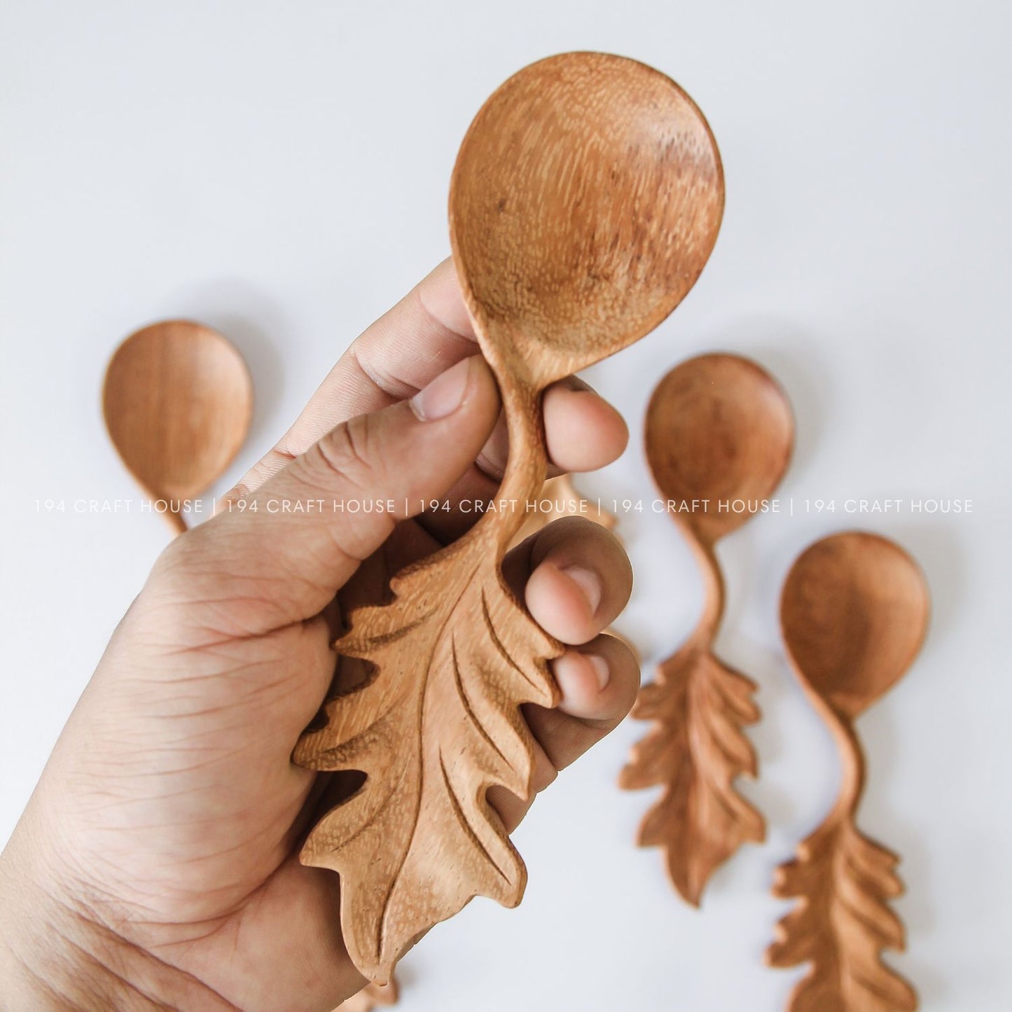 Set of handcrafted wooden spoons with decorative leaf-shaped handles and unique natural wood grain