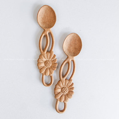Handcarved wooden spoons with decorative flower-shaped handles showcasing natural wood grain variations