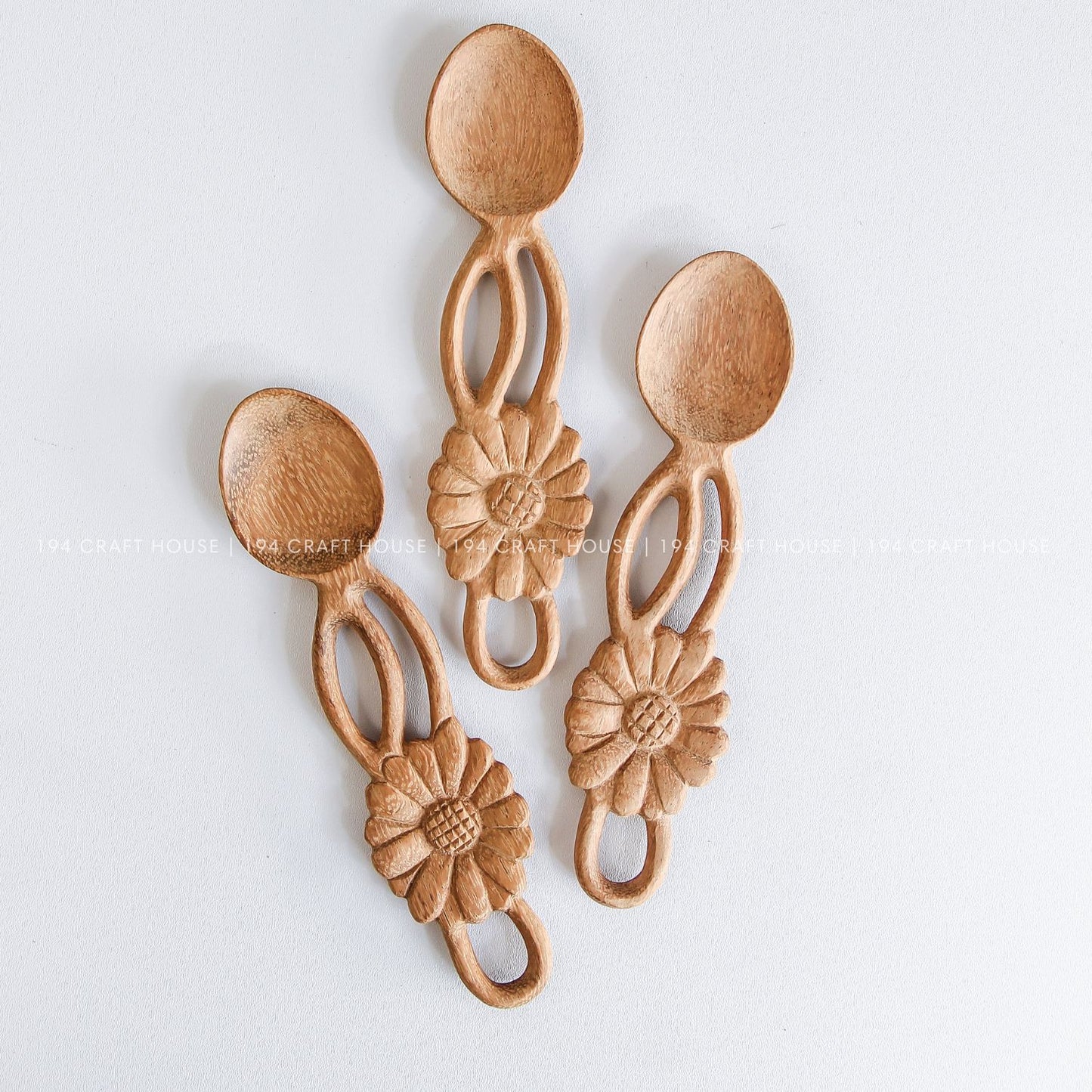 Close-up of handcrafted flower-shaped wooden spoons showcasing decorative handles and natural artisan details