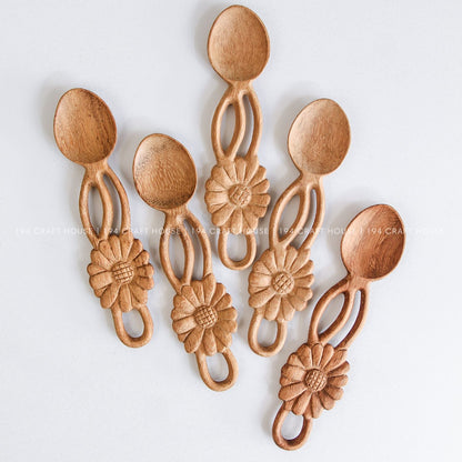 Collection of handcrafted wooden spoons with decorative flower-shaped handles and unique natural wood grain
