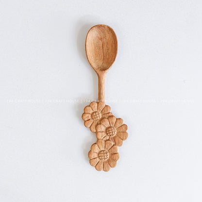 Handcrafted wooden spoon with a decorative three-flowers handle and natural wood grain