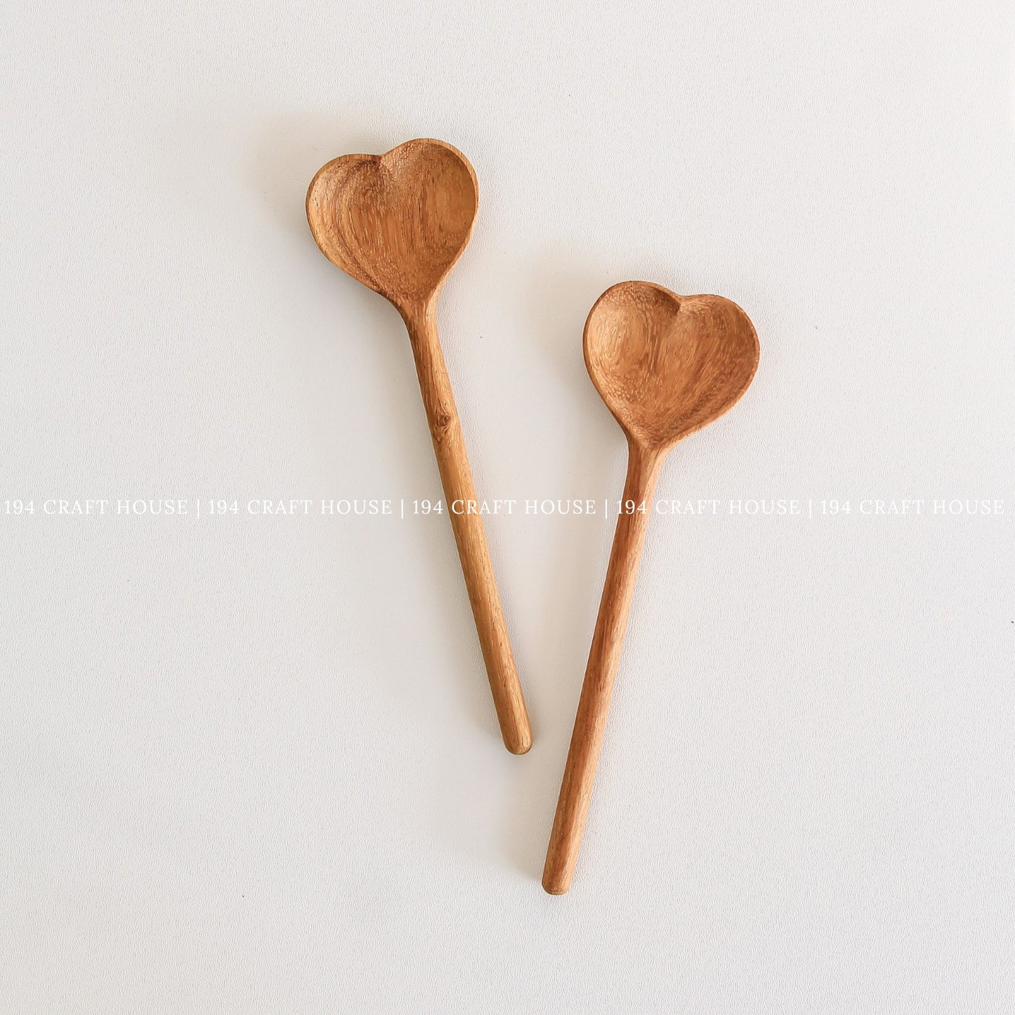 Pair of handcrafted heart-shaped wooden spoons with natural wood grain