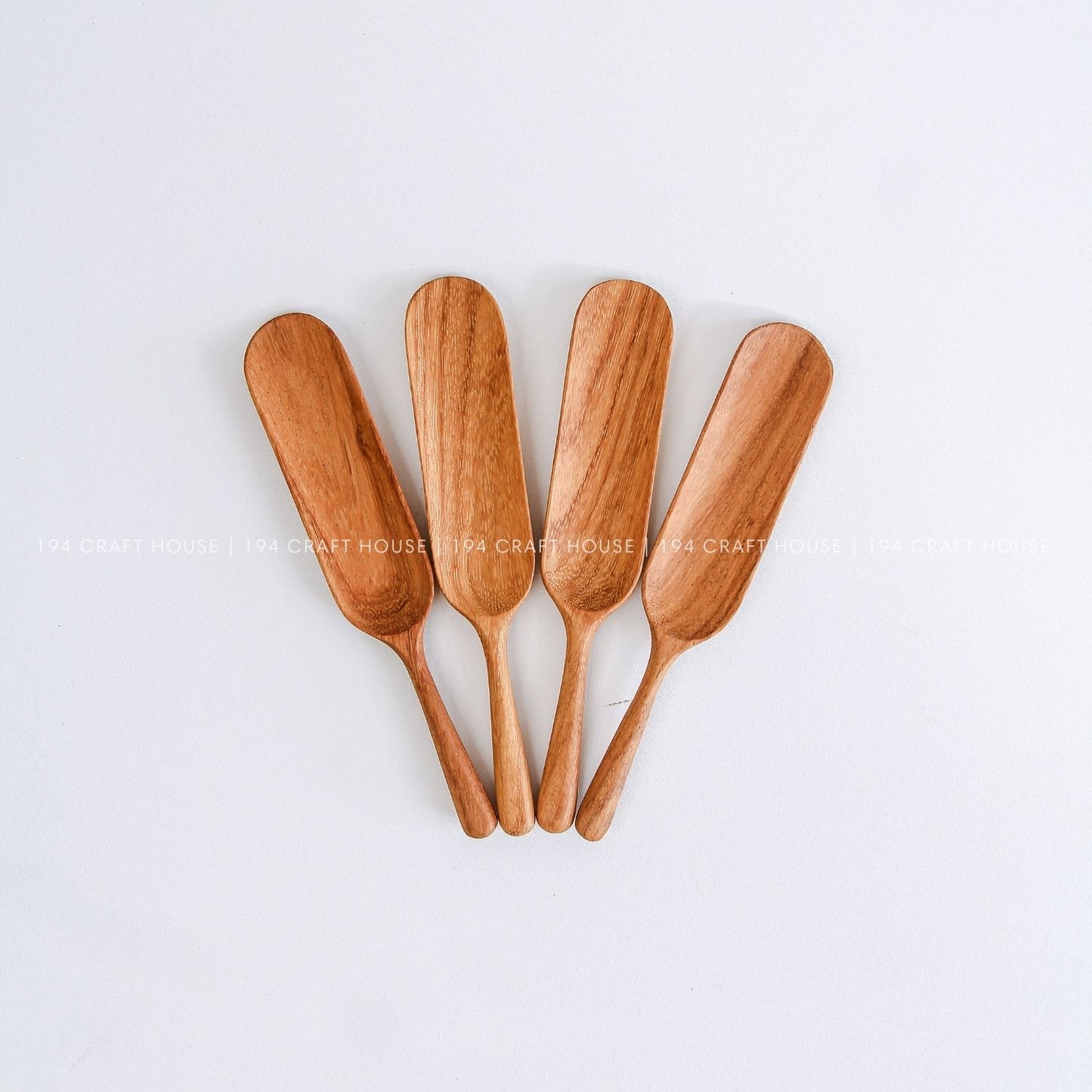 Five handcrafted wooden tea spoons showing natural wood grain variations