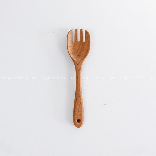 Single handcrafted wooden salad fork displayed vertically on a white background
