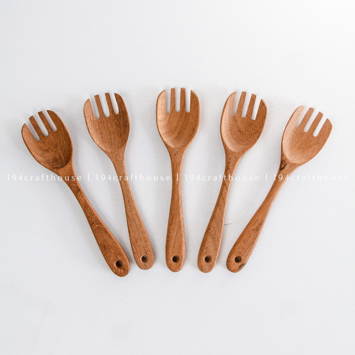Five handcrafted wooden salad forks displayed in a fan arrangement