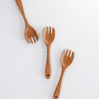 Three wooden salad forks arranged together on a white background