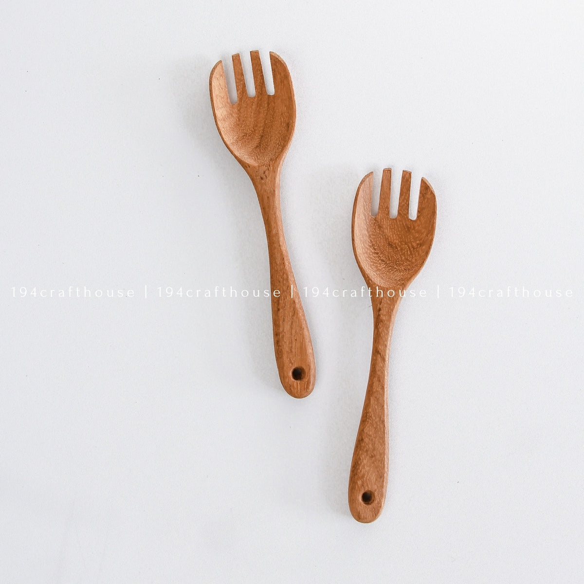 Pair of wooden salad forks arranged diagonally on a white background