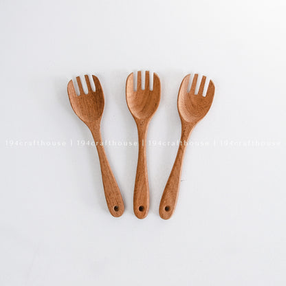 Three handcrafted wooden salad forks arranged upright on a white background