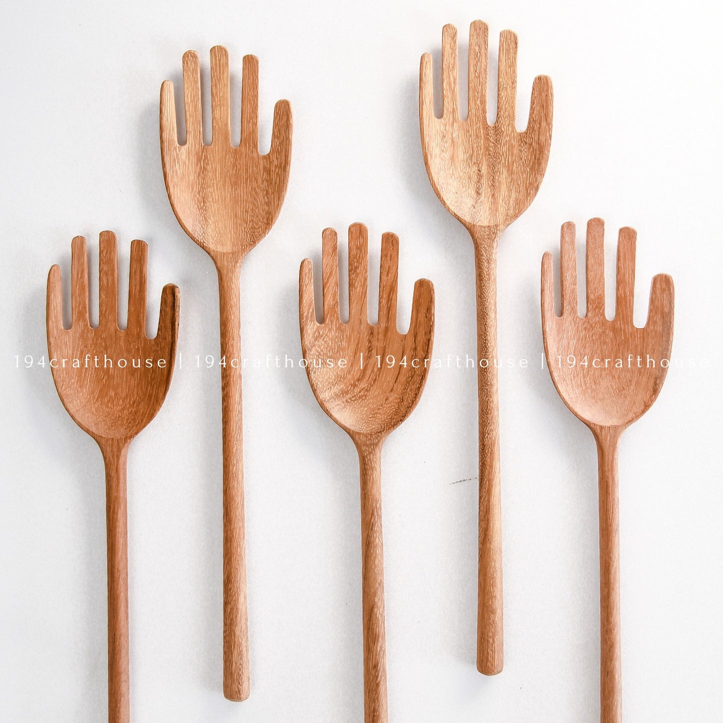 Collection of unique wooden salad servers with whimsical hand-shaped designs