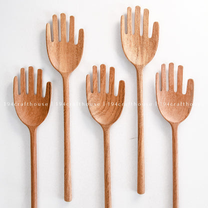 Collection of unique wooden salad servers with whimsical hand-shaped designs